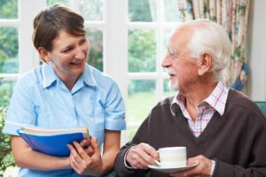 Older adult speaking with a caregiver in a bright assisted living apartment